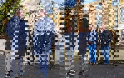 Representatives from Zenith Mechanical Services, Prosper, Tyne Housing, Keelman Homes, North Star Housing, Livin Housing, and Durham Aged Mineworkers’ Homes smiling outside a terraced property
