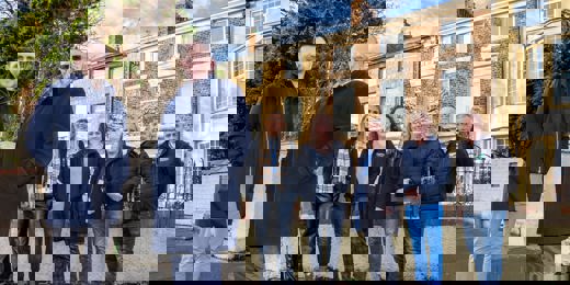 Representatives from Zenith Mechanical Services, Prosper, Tyne Housing, Keelman Homes, North Star Housing, Livin Housing, and Durham Aged Mineworkers’ Homes smiling outside a terraced property